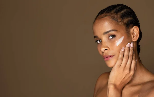 アンチエイジングや保湿クリームを施した黒中年女性のポートレートで 茶色いスタジオの背景にポーズをとり スペースをコピーします 顔のケア リフティング アンチエイジング 栄養化粧品の概念 — ストック写真