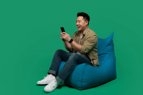 Захоплений Азіатський Чоловік Який Використовує Мобільний Телефон Смс Або Перегляд — стокове фото