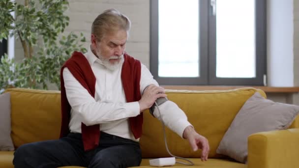 Selbstkontrolle Älterer Mann Mit Blutdruckproblemen Der Sich Hause Selbst Misst — Stockvideo