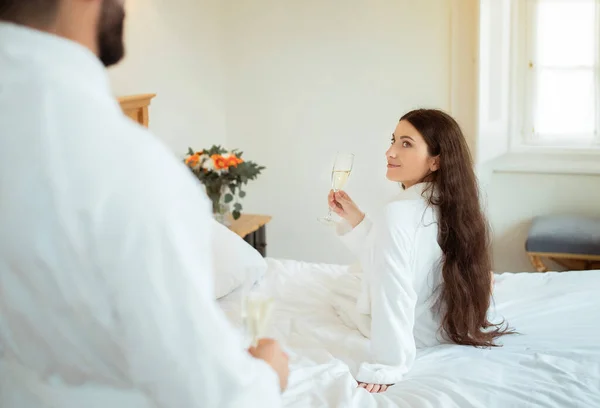 남녀가 반짝이는 안경을 남편을 바라보며 실내에서 침대에 목욕을 사람들은 즐기는 — 스톡 사진