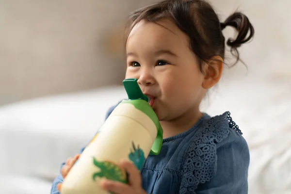 베이즈 하이드라 집에서 우유병을 마시는 동양인아이 스러운 아이가 마시며 바라보고 — 스톡 사진