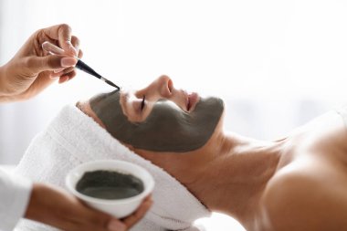 Yaşlanan Cilt Bakımı Karşıtı. Modern Spa Salonunda Çamur Maskesi Uygulayan Profesyonel Kozmetikçi Doktor Çekici Olgun Kadın Cilt Bakımı Yapıyor