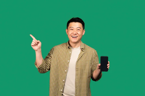Szczęśliwy Azjatycki Mężczyzna Średnim Wieku Pokazuje Telefon Komórkowy Pustym Ekranem — Zdjęcie stockowe