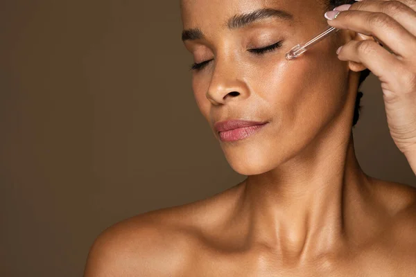 Primer Plano Mujer Negra Mediana Edad Aplicando Suero Facial Hidratante —  Fotos de Stock