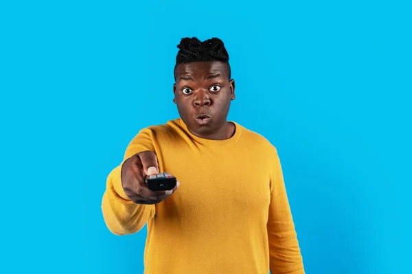 Geschokte Zwarte Man Kijken Televisie Wijzend Afstandsbediening Bij Camera Verbazingwekkende — Stockfoto