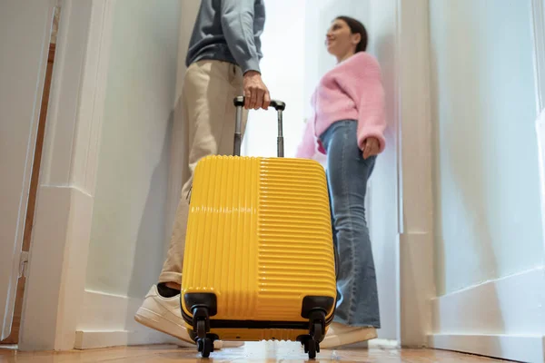 ドアウェイに立つ認識できない観光客カップルホテルの室内に入ると クロップドショット 黄色の旅行スーツケースに選択的な焦点 休暇と宿泊のコンセプト — ストック写真