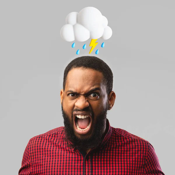 stock image Angry aggressive young african american man scream with open mouth with abstract cloud of lightning, rain sign above head isolated on gray studio background. Bad mood, negative emotion and stress