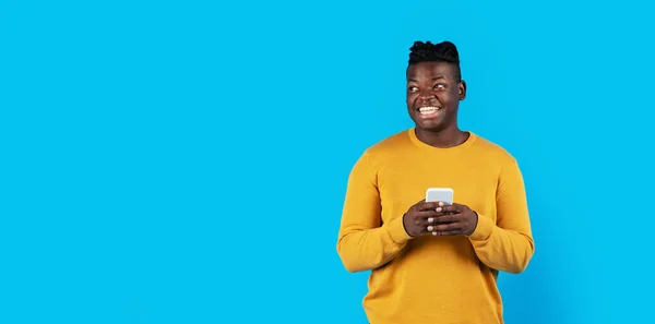 Smiling Black Guy Holding Mobile Phone Looking Aside Copy Space — Stock Photo, Image