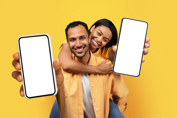 Smiling Millennial Black Guy Hold Back Lady Show Smartphone Blank — Stok Foto