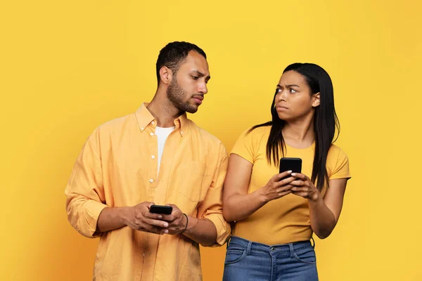Nešťastný Smutný Tisíciletý Afroameričan Dívá Smartphone Šťastné Ženy Izolované Žlutém — Stock fotografie