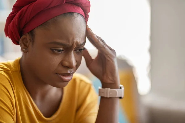 頭に触れる伝統的なアフリカのターバンを身に着けている不幸な不満を抱えた若い黒人女性の閉鎖 頭痛の種に苦しんで ストレスを経験 家のインテリア コピースペース — ストック写真