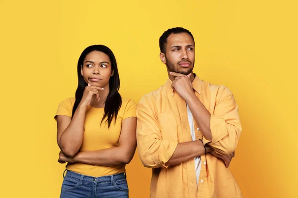 何千年ものアフリカ系アメリカ人のボーイフレンドと女性が空の空間を見て 黄色のスタジオの背景に隔離されていると思う 広告やオファー 販売や人々の感情 — ストック写真