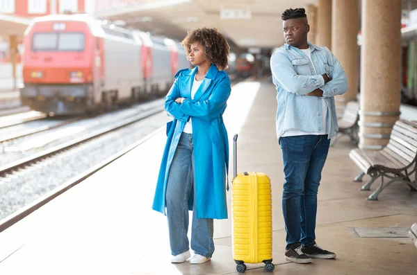 Relationship Crisis. Offended Black Couple Standing On Platform At Railway Station, Young African American Man And Woman Ignoring Each Other After Argue, Suffering Problems While Travelling Together