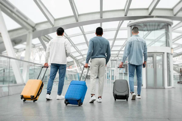Baksidan Tre Manliga Turister Promenader Med Resväskor Moderna Flygplatsen Inomhus — Stockfoto