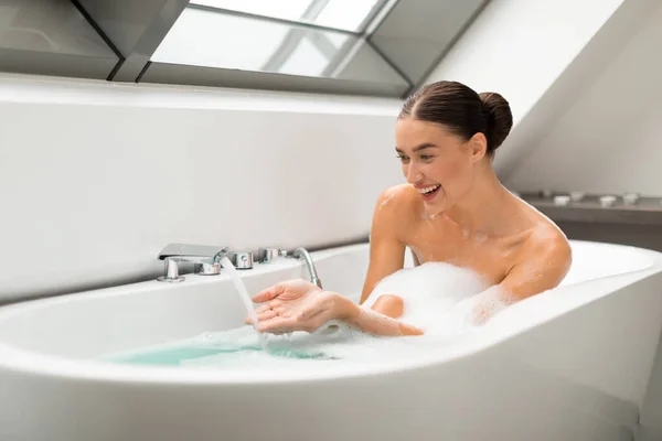 Emocionado Baño Femenino Con Espuma Sentada Bañera Tocando Agua Caliente —  Fotos de Stock