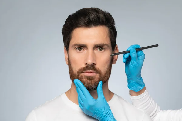 審美的な化粧品の概念 中年男性美容整形のための顔に鉛筆マークを取得 整形外科手術前に男性の顔にマークを適用 — ストック写真
