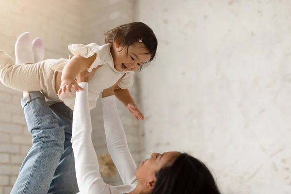 Neşeli Çinli Anne Sevimli Küçük Kızıyla Oynuyor Çocuğunu Bacaklarıyla Kaldırıyor — Stok fotoğraf