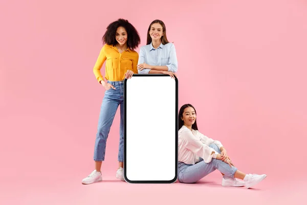 Kolla Här Tre Kvinnliga Vänner Poserar Nära Stora Smartphone Med — Stockfoto