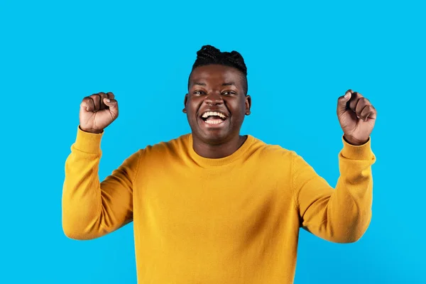 情绪激动的非洲裔美国人举起拳头庆祝胜利 快乐激动的黑人年轻人欢呼胜利 站在蓝色的背景上对好消息做出情绪反应 复制空间 — 图库照片