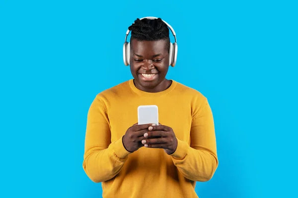 Vidám Fiatal Fekete Férfi Visel Vezeték Nélküli Fejhallgató Segítségével Okostelefon — Stock Fotó
