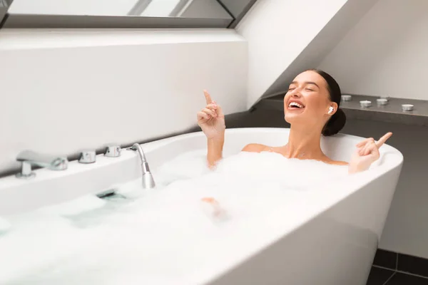 Woman Taking Bath Foam Enjoying Relaxing Playlist Wearing Earbuds Earphones — Stok Foto