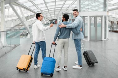 Arkadaşlarla Tatil. Üç Gezgin Adam Grubu Modern Havalimanı 'nda vakit geçiriyorlar. Uçağın kalkmasını bekleyen yolcular bavullarını içeri taşıyorlar. Tam Uzunluk Çekimi
