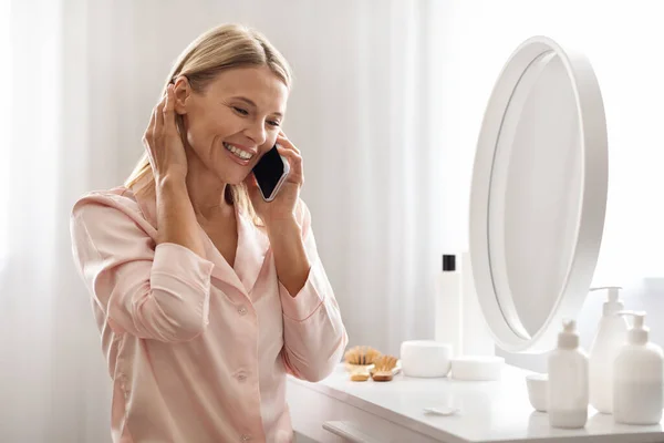 Счастливая Женщина Средних Лет Разговаривает Мобильному Телефону Сидя Столом Одежды — стоковое фото