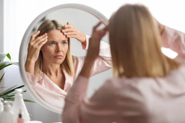 Mulher Meia Idade Olhando Espelho Tocando Rugas Seu Rosto Perturbado — Fotografia de Stock