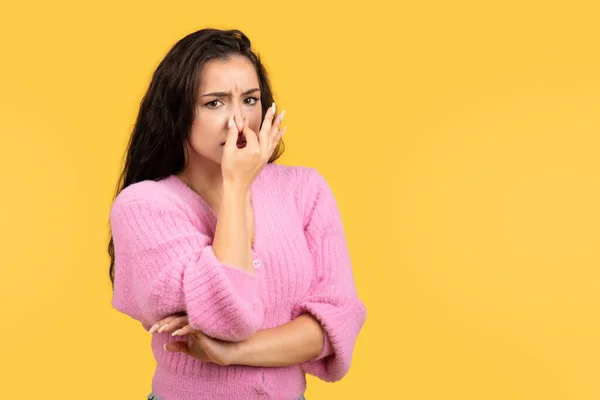 可悲的千禧年中东女性用手捂住鼻子 在黄色的工作室背景下 身上散发出难闻的气味 人的情感 广告和奉献 — 图库照片
