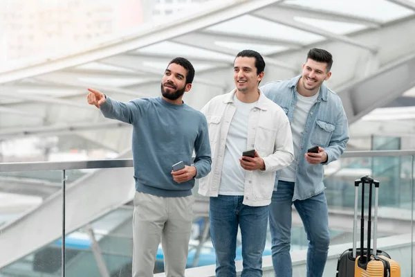 Tři Cestovatelé Muži Pomocí Chytrých Telefonů Ukazující Prst Aside Stojící — Stock fotografie