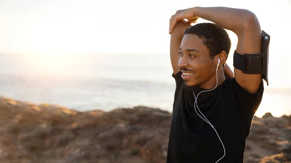 Χαμογελώντας Χιλιετή Αφροαμερικανός Άνδρας Τηλέφωνο Και Ακουστικά Κάνει Ασκήσεις Τεντώματος — Φωτογραφία Αρχείου