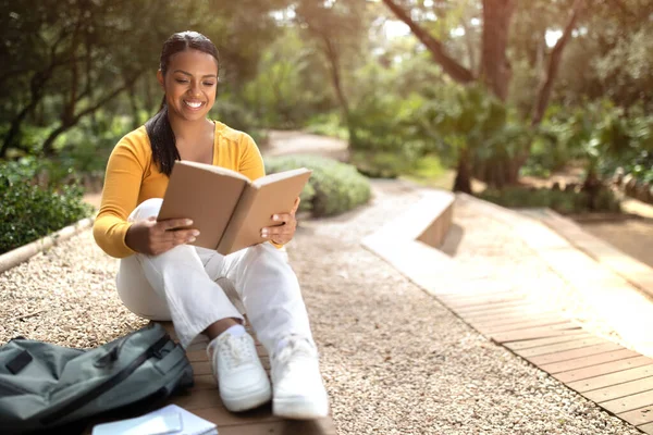 快乐的巴西女学生在户外看书 坐在大学校园或公园里准备讲座或上课 免费复印 — 图库照片