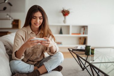 Haberler iyi, uzaktan çalış. Bin yıllık Asyalı kadın videolarını telefonda izlediği için memnunum. Oturma odasının iç kısımlarında boş zamanlarının tadını çıkar. İletişim, çevrimiçi alışveriş uygulaması, sosyal ağlarda sohbet