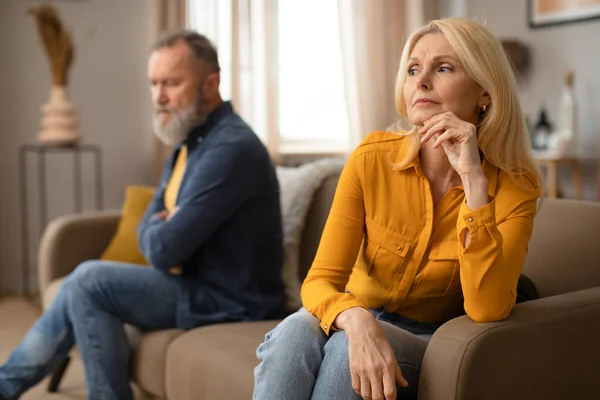 stock image Unhappy Mature Couple Having Marital Crisis Sitting On Sofa On Different Sides And Thinking About Divorce At Home. Marriage Problems Concept. Selective Focus On Upset Lady