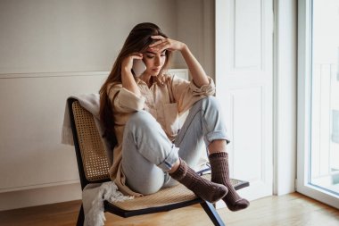 Üzgün, dalgın, bin yıllık Avrupalı bayan. Akıllı telefondan arıyor, konuşuyor, minimalist odada oturuyor. Yalnızlık, kötü haberlere tepki, dedikodu, evde stres.