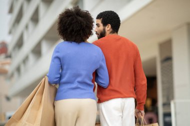 Alışveriş Teklifi. Alışveriş meraklıları, alışveriş torbaları ve paketlerle modern alışveriş merkezinin yakınındaki kameraya doğru yürüyorlar. Haftasonu Satış Reklamı. Seçici Odaklanma