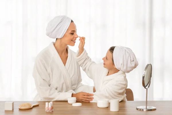 Cute Little Daughter Applying Cream Her Mothers Face Home Mom — Stock Photo, Image