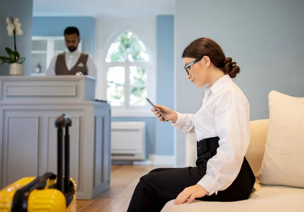 Bizneswoman Korzystanie Smartphone Rezerwacja Pokoju Online Aplikacji Siedząc Recepcji Hotelu — Zdjęcie stockowe
