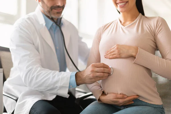 产前护理概念 在产科医院 男医生用听诊器检查孕妇的腹部 听婴儿的心跳 — 图库照片