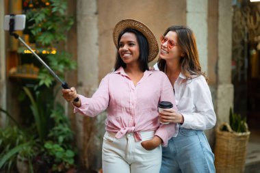 Pozitif genç bayan turist blogcuları şapkalı, kahve bardağıyla güneş gözlüğü takan, telefonda selfie çeken, şehirde maceranın tadını çıkaran. Hafta sonu, tatil, açık hava gezisi blog ve fotoğraf turu.