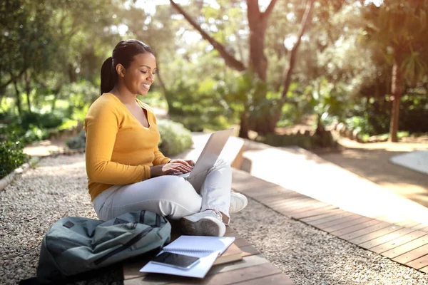 距離教育の概念 ラップトップコンピュータを屋外に座って オンラインの遠隔講義 フリースペースに参加して幸せなブラジルの女性学生 — ストック写真