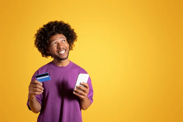 스마트폰 카드가 보라색 티셔츠를 아프리카 미국인 곱슬머리의 남자가 공간을 바라보며 — 스톡 사진