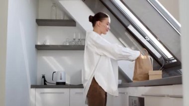 Neşeli yemek dağıtım servisi. Genç, güzel bir kadın, karton bir kutuyu hamburgerle alıp açıyor, iştah açıcı yemek kokusunun tadını çıkarıyor, yemek odasına gidiyor, bedava yer açıyor.