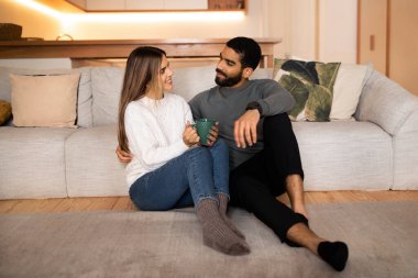 Pozitif aşıklar genç Avrupalı kadın ve Arap koca yerde oturur, oturma odasının içinde romantik bir buluşmanın tadını çıkarırlar. Akşamları boş zaman, aşk, ilişki ve aile evde.