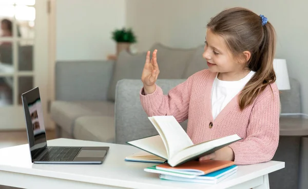 Smiling European Teenager Girl Doing Homework Reading Book Waving Hand — Stock Photo, Image