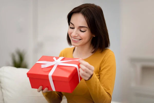 클로즈업은 소파에 상자를 날이나 기념일 상자를 행복하게 미소짓는 아름다운 여성의 — 스톡 사진