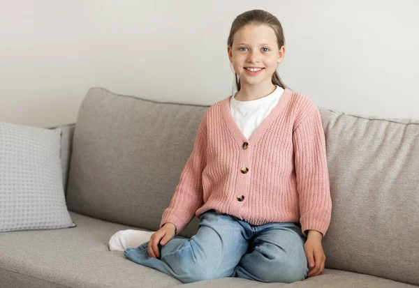 明るく幸せなカジュアルなヨーロッパの10代の女の子は 楽しい時間をお楽しみください リビングルームのインテリア 無料のスペースでソファの上に座っている 家庭での休憩 子供時代とライフスタイル — ストック写真