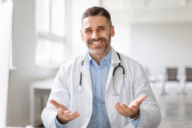 Hastaların erkek doktorla görüşü, doktorun kamerayla konuşması, el kol hareketi, profesyonel doktorun ofisinde oturan hastaya tedaviyi açıklaması.