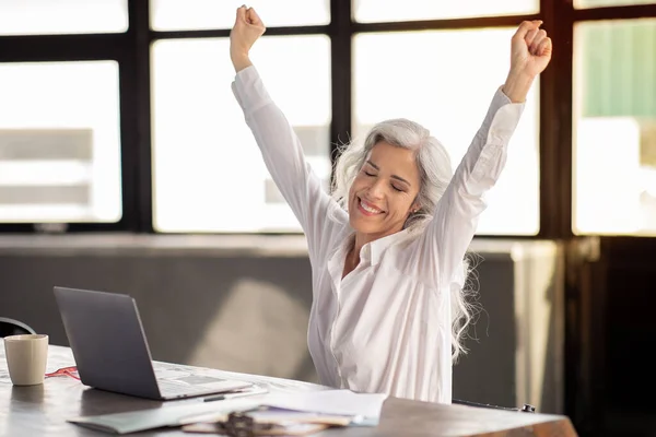 Joyful Middle Aged Businesswoman Shaking Fists Sitting Laptop Celebrating Business — Stock Photo, Image