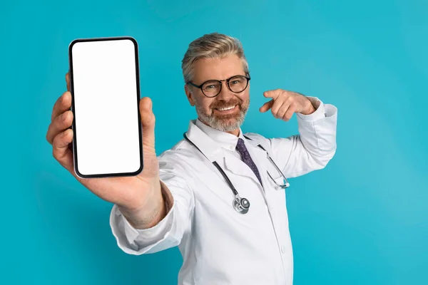 Χαμογελώντας Όμορφος Γκριζομάλλης Ώριμος Καυκάσιος Γιατρός Που Δείχνει Κινητό Τηλέφωνο — Φωτογραφία Αρχείου